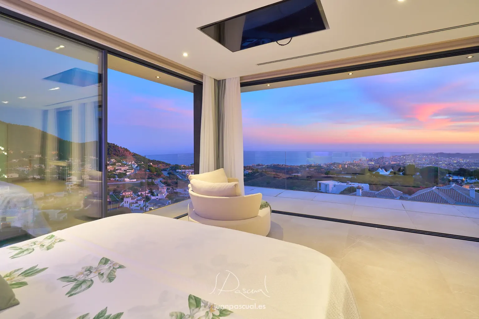 Fotografía de atardecer desde el dormitorio principal de una villa, obra del fotógrafo de arquitectura Juan Pascual. Vivienda de estilo moderno localizada en la ladera de montaña en Marbella.